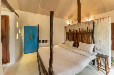 a bedroom with a large white bed in a room at Deshadan Eco Valley Resort - An Eco friendly Mud House in Kanthalloor