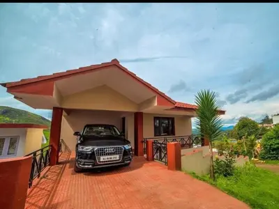 a car parked in the driveway of a house at Mist Resorts Ooty in Ooty