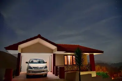a car parked in front of a small house at Mist Resorts Ooty in Ooty