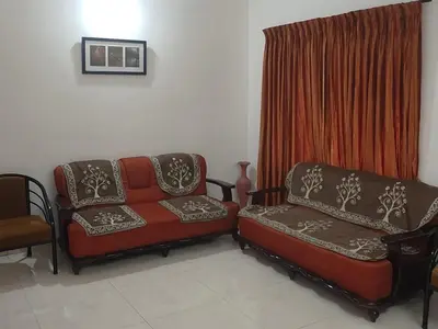 a living room with a couch and a chair at Mist Resorts Ooty in Ooty