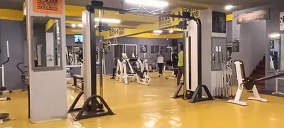 a gym with rows of machines and people in it at Hotel Chanma International in Coimbatore