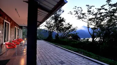 a group of red chairs sitting on a porch at Ottway Hills Mattupetty Dam in Munnar