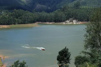 a boat in the middle of a lake at Ottway Hills Mattupetty Dam in Munnar