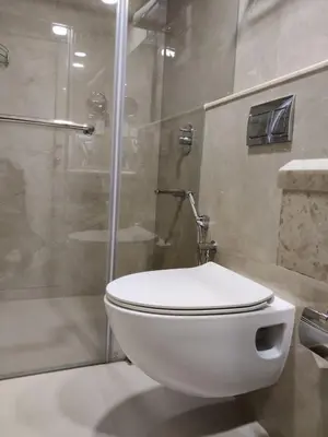 a white toilet in a bathroom with a shower at Issacs Residency in Munnar