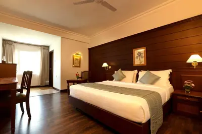a hotel room with a large bed and a desk at Issacs Residency in Munnar