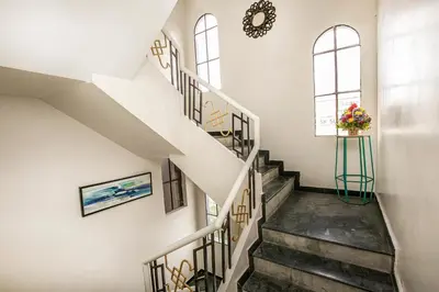 a staircase in a building with a window and a vase of flowers at Aishwarya Le Royal in Mysore