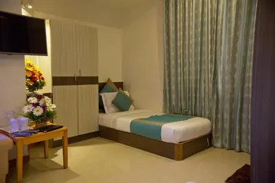 a hotel room with a bed and a television at Aishwarya Le Royal in Mysore