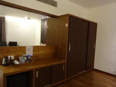 a locker room with a mirror and a closet at Woodies Bleisure Hotel in Kozhikode