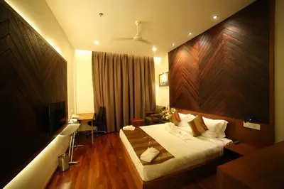 a hotel room with a bed and a wooden wall at Woodies Bleisure Hotel in Kozhikode