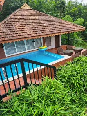 a swimming pool with a gazebo in a yard at Athirapally Green Trees in Athirappilly