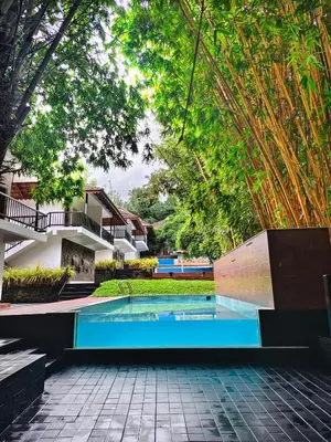 a swimming pool in a courtyard with trees at Athirapally Green Trees in Athirappilly