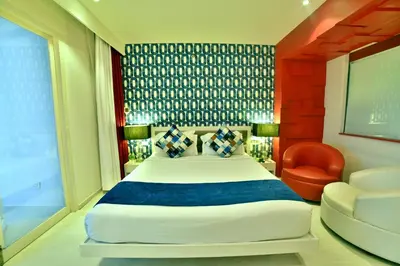 a bedroom with a large bed and a chair at M Inn in Coimbatore