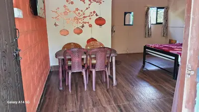 a dining room with a table and chairs in a room at Green Hills Farm And Guest House in Masinagudi