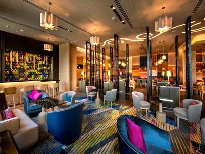 a lobby with chairs and tables and a bar at Welcomhotel by ITC Hotels, RaceCourse, Coimbatore in Coimbatore
