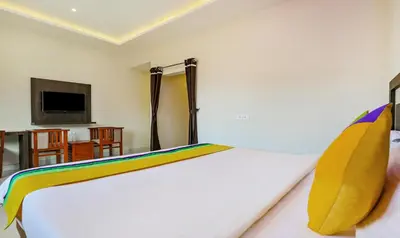 a bedroom with a bed and a tv on a wall at Itsy Hotels Kottaram Residency, 10 Mins To Botanical Garden in Ooty