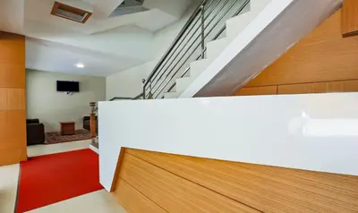 a staircase in a house with a white wall at Itsy Hotels Kottaram Residency, 10 Mins To Botanical Garden in Ooty