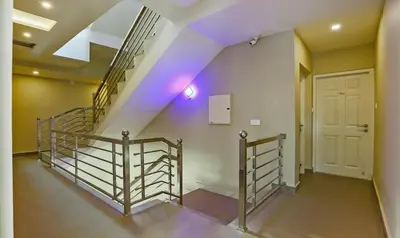 a staircase with purple lights in a building at Itsy Hotels Kottaram Residency, 10 Mins To Botanical Garden in Ooty