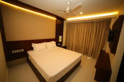 a bedroom with a bed and a ceiling fan at Vavas Inn & Suites in Perintalmanna