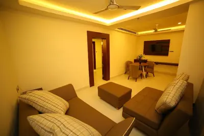 a living room with a couch and a table at Vavas Inn & Suites in Perintalmanna