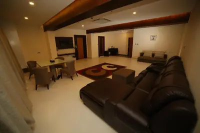 a living room with a leather couch and a table at Vavas Inn & Suites in Perintalmanna