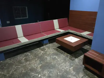 a red couch and a coffee table in a room at The Shades Holiday Homes in Kushālnagar
