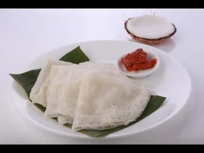 a white plate with some food on a table at The Shades Holiday Homes in Kushālnagar