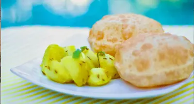 a white plate with some food on a table at The Shades Holiday Homes in Kushālnagar