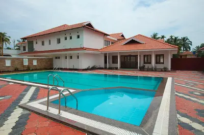 a swimming pool in front of a house at Le Coffee Resort in Sultan Bathery