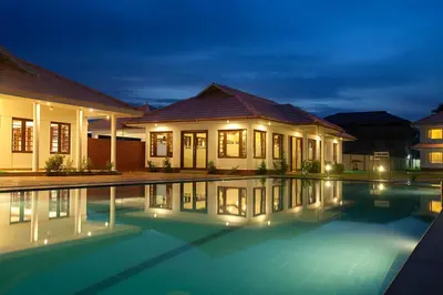 a house with a swimming pool at night at Le Coffee Resort in Sultan Bathery