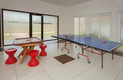 a room with a ping pong table and two stools at Le Coffee Resort in Sultan Bathery