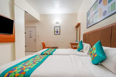 a bedroom with two beds and a flat screen tv at Treebo Sam Residency in Coimbatore