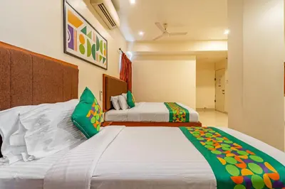 a bedroom with two beds with green pillows at Treebo Sam Residency in Coimbatore