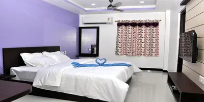 a bedroom with a bed with a blue bow on it at Sara Regency in Palani