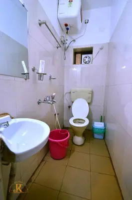 a bathroom with a white sink and a toilet at Royal Serene Villas in Ooty