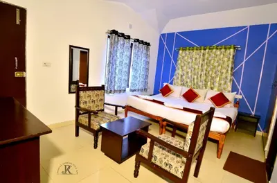 a bedroom with a bed and a table and chairs at Royal Serene Villas in Ooty