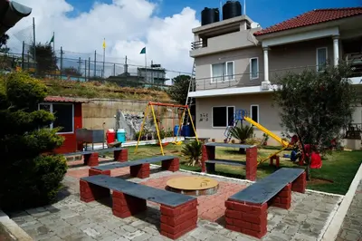 a park with benches and a playground in front of a building at Paradise Perfect - Nonsmoking Non alcoholic No unmarried couples in Ooty