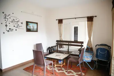 a living room with a table and chairs at Paradise Perfect - Nonsmoking Non alcoholic No unmarried couples in Ooty
