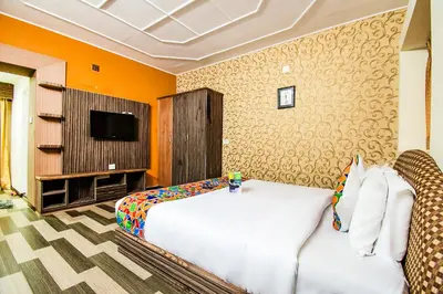 a bedroom with a white bed and a tv at Via St Clouds - Nr Government Botanical Garden in Ooty