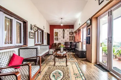 a living room with couches and a table at Via St Clouds - Nr Government Botanical Garden in Ooty