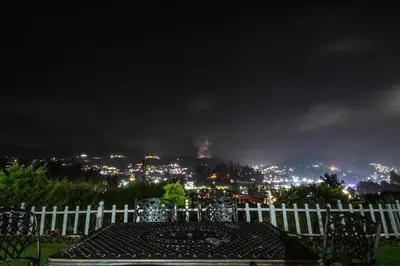 a view of a city at night with a white fence at Via St Clouds - Nr Government Botanical Garden in Ooty