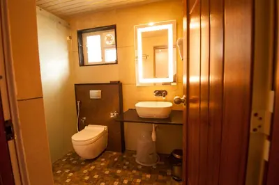 a bathroom with a toilet and a sink and a mirror at MC Resort Wildlife Resort Bandipur in Bandipūr