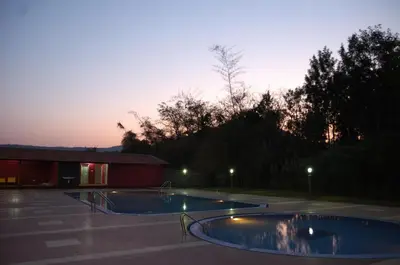 a swimming pool in a parking lot at dusk at MC Resort Wildlife Resort Bandipur in Bandipūr