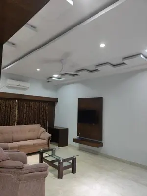 a living room with two couches and a flat screen tv at Bandipur Wildlife Resort & Spa, Bandipur in Bandipūr