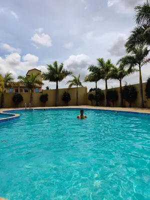 a man in a swimming pool with palm trees at Bandipur Wildlife Resort & Spa, Bandipur in Bandipūr