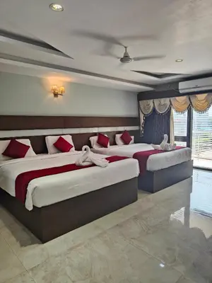a bedroom with two beds with red pillows at Bandipur Wildlife Resort & Spa, Bandipur in Bandipūr