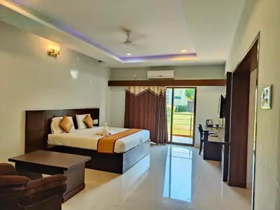 a bedroom with a bed and a table in a room at Bandipur Wildlife Resort & Spa, Bandipur in Bandipūr