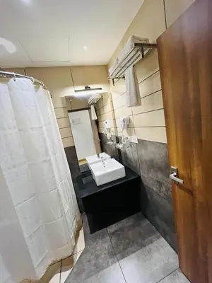 a bathroom with a white sink and a mirror at Queens Tourist Home in Badagara