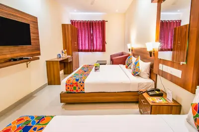 a hotel room with a bed and a flat screen tv at FabHotel Thejas Paaradise - Nr Coimbatore Institute of Technology in Coimbatore