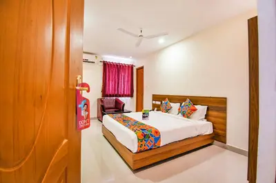 a bedroom with a bed and a chair in it at FabHotel Thejas Paaradise - Nr Coimbatore Institute of Technology in Coimbatore