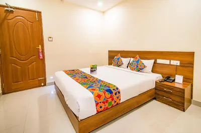 a bedroom with a bed and a wooden door at FabHotel Thejas Paaradise - Nr Coimbatore Institute of Technology in Coimbatore